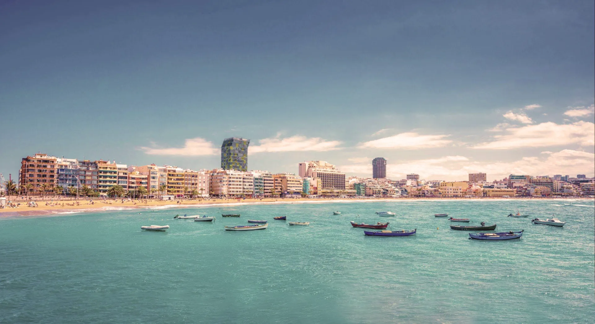 Playa de Las Canteras con barcas de pescadores y el paseo de Las Palmas de Gran Canaria al fondo.