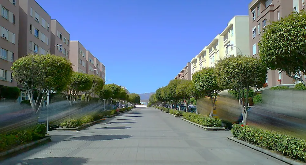 Avenida residencial con jardines y edificios en Siete Palmas.
